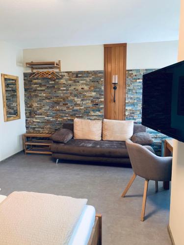a living room with a couch and a tv at Hotel-Bistro-Europa in Merchweiler