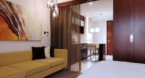 a living room with a couch and a kitchen at Centro Olaya by Rotana in Riyadh