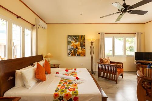 a bedroom with a bed and a ceiling fan at Villa Aya in Grand'Anse Praslin