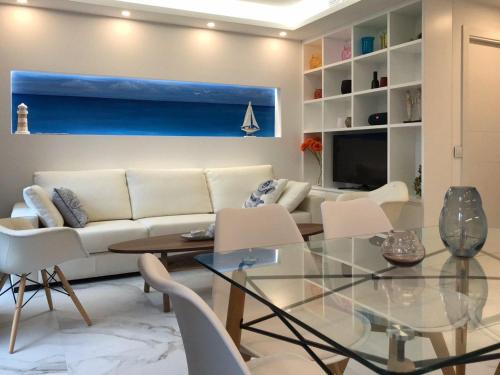 a living room with a white couch and a glass table at Nuevo Luminoso Apartamento Catalina a 80 metros de la playa para 4 personas in Sant Feliu de Guixols