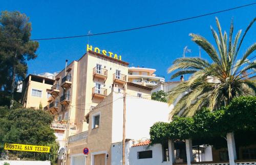 un edificio con una palma di fronte di Hostal San Telmo a Palma de Mallorca
