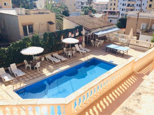 una piscina con sedie e ombrelloni accanto a un edificio di Hostal San Telmo a Palma de Mallorca