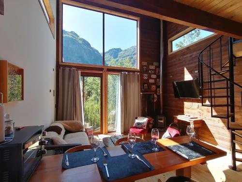 a living room with a table and some windows at The Loft in Las Trancas