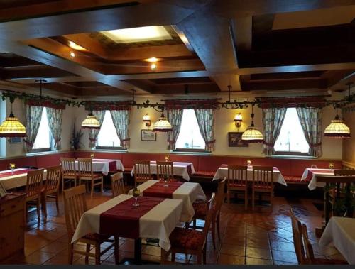 una sala da pranzo con tavoli, sedie e finestre di vidimo se a Selzthal