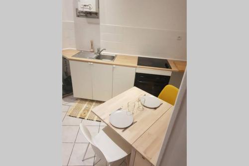 a kitchen with a wooden table and yellow chairs at Cosy home near Paris in Gagny