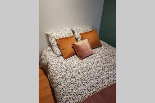 a bed with three pillows on it in a room at Cosy home near Paris in Gagny