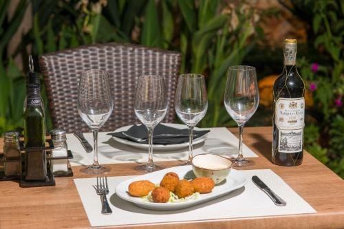 a table with a plate of food and wine glasses at My Way Luxury Ibiza Studio - AB Group in Playa d'en Bossa