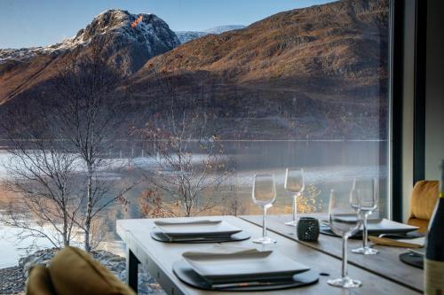 a table with wine glasses and a view of a mountain at Isbreen The Glacier in Jøkelfjord