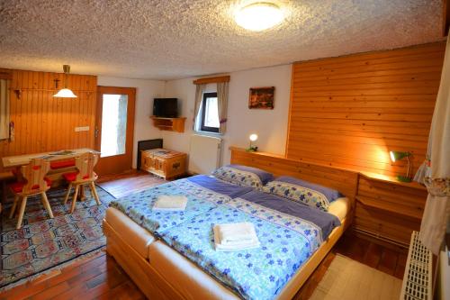 a bedroom with a bed and a dining room at Apartmaji Zupančič in Bohinj
