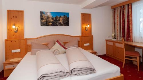 1 dormitorio con 1 cama con sábanas y almohadas blancas en Haus Handle, en Kappl