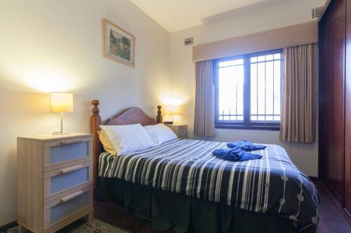 a bedroom with a bed with a blue shirt on it at B3 Crawley Apartment 1 BRM & Sleepout near UWA in Perth