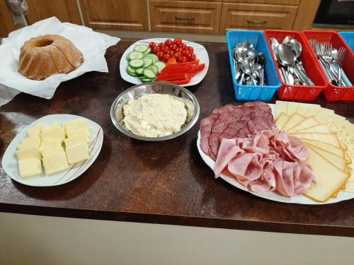 a counter topped with plates of cheese meat and other foods at Buchtův statek in VendolÃ­