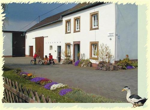 une maison avec 2 personnes à vélo et un canard dans l'établissement Ferien auf dem Bermeshof, à Preischeid