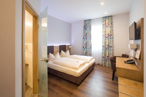 a hotel room with a bed and a desk at Hotel Bauer garni in Ingolstadt