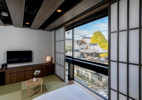 a bedroom with a large window with a view at 谷町君・ホテルひとめぼれ 京都四条烏丸 in Kyoto