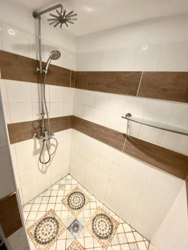 a bathroom with a shower with a tile floor at Hotel du Pont de l'Oso in Cala Rossa