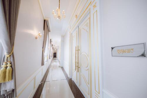 a hallway with white walls and a chandelier at Morakot Twin Chumphon in Chumphon
