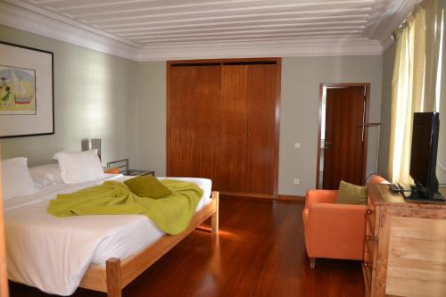 a bedroom with a large bed and a chair at Pousada de Angra do Heroismo Castelo de S. Sebastiao in Angra do Heroísmo