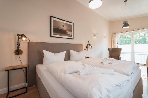 1 dormitorio con 1 cama grande con sábanas blancas en Das Handtuchhaus - Wohnen im schmalsten Haus - Mittendrin, en Heringsdorf