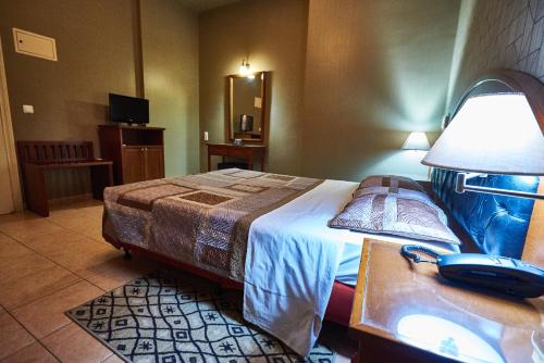 a hotel room with a bed and a phone on a table at Exis Hotel in Athens