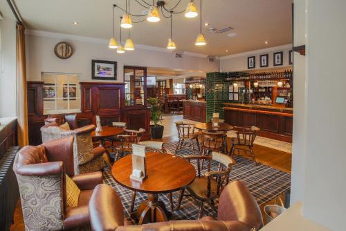 a restaurant with tables and chairs and a bar at Norfolk Arms in Glossop