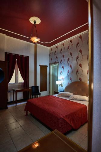 a bedroom with a large bed with a red blanket at Exis Hotel in Athens