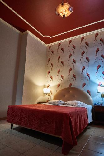 a bedroom with a bed with a red bedspread at Exis Hotel in Athens