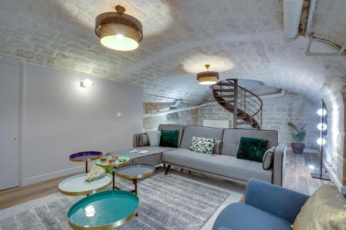 - un salon avec un canapé, des tables et un escalier dans l'établissement Sweett - Trevise, à Paris
