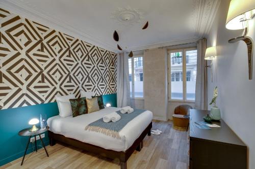 - une chambre dotée d'un lit avec un mur géométrique dans l'établissement Sweett - Trevise, à Paris