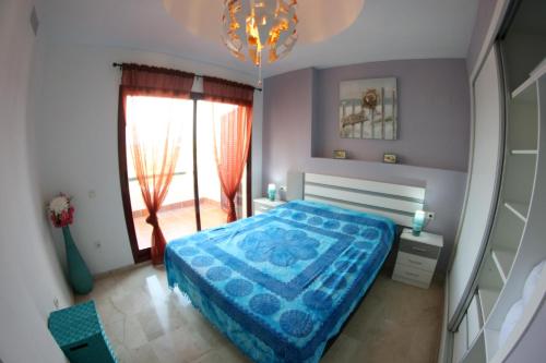 カサーレスにあるVista Bahíaのベッドルーム(青いベッド1台、窓付)