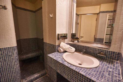 a bathroom with a sink and a mirror at Exis Hotel in Athens