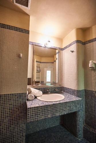 a bathroom with a tub and a large mirror at Exis Hotel in Athens