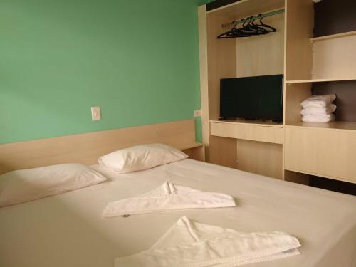 1 dormitorio con 1 cama con 2 toallas en Colônia de Férias de Guaratuba, en Guaratuba