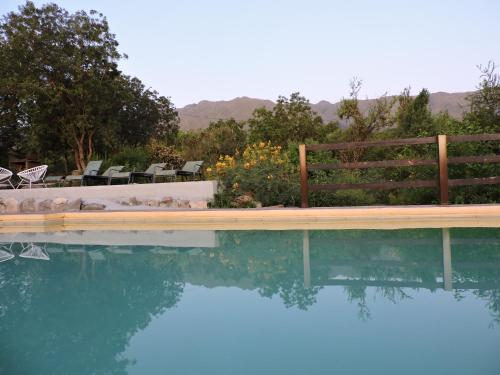 una piscina con un banco y algunas sillas en Cabañas La Comarca en Merlo