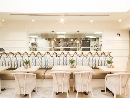 a restaurant with tables and chairs and a kitchen at Sandy Mount House in Rhosneigr