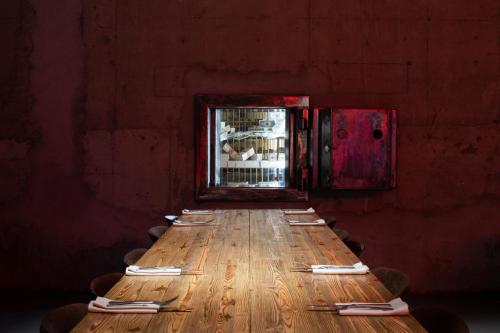 a long wooden table with plates and utensils on it at Zero Box Lodge Porto in Porto
