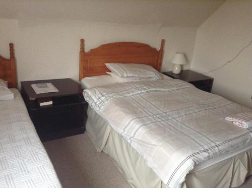 a bedroom with a large bed and a night stand at Park House Guest House in Warwick