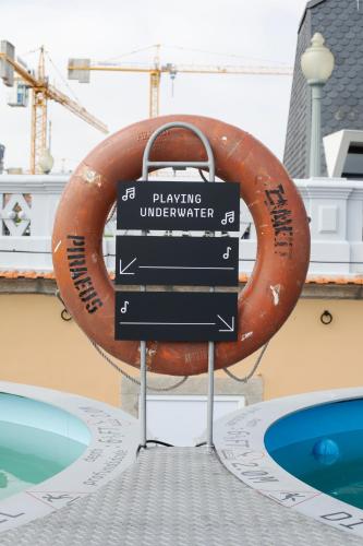 a sign in front of a swimming pool at Zero Box Lodge Porto in Porto