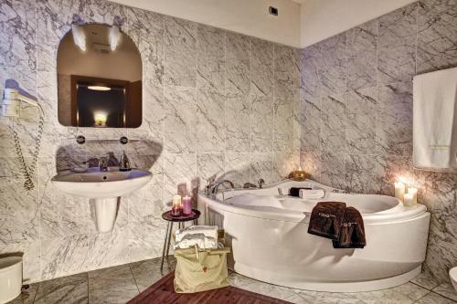 bagno con vasca e lavandino di Hotel Regina a San Martino di Castrozza