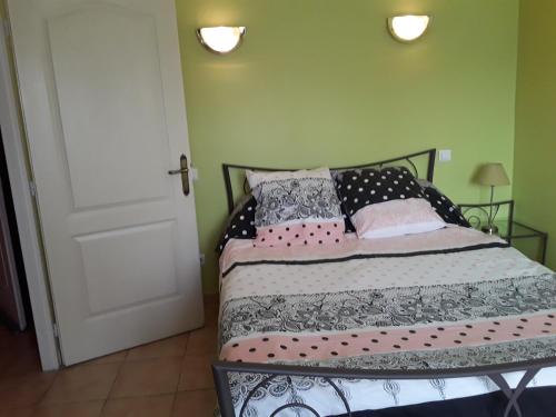 - une chambre avec un lit doté d'oreillers roses et noirs dans l'établissement Gite au coeur de Provence, à LʼIsle-sur-la-Sorgue