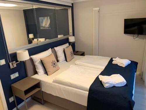 ein Hotelzimmer mit einem Bett und einem Spiegel in der Unterkunft Ostseeblick Rügen in Binz