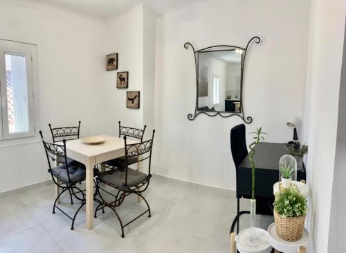 a dining room with a table and chairs and a mirror at T2 bis cosy climatisé, Intra Muros Avignon in Avignon
