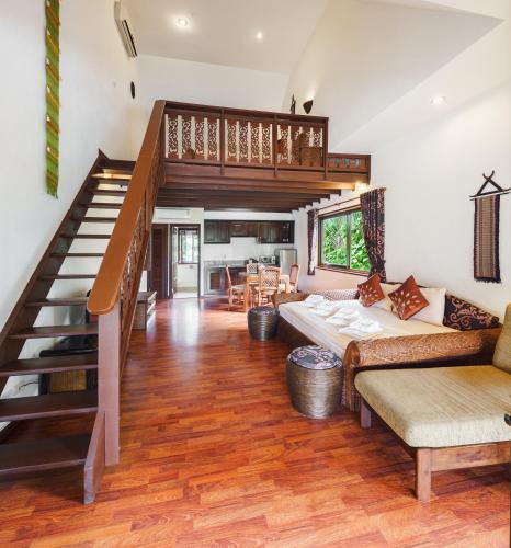 a living room with a staircase and a couch at Royal Cottage Residence in Lamai