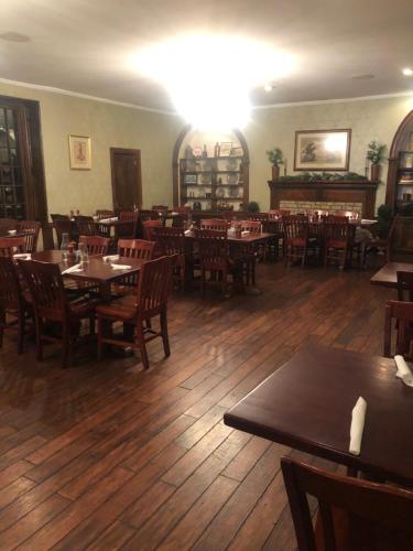 restauracja z drewnianymi podłogami, stołami i krzesłami w obiekcie Talbott Tavern and Inn w mieście Bardstown