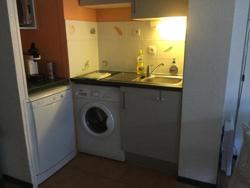 a kitchen with a washing machine and a sink at ANGLET- BIARRITZ T3 dans résidence avec piscine in Anglet