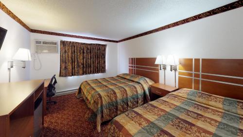 Waconia Inn and Suites في Waconia: غرفة فندقية بسريرين ومكتب