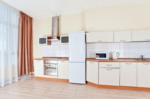 a kitchen with white cabinets and a white refrigerator at Lukyanovsky in Kyiv