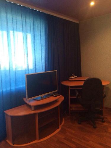a room with a desk with a computer monitor and a chair at Квартира 40 лет Победы,12 in Bratsk