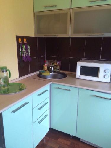 a kitchen with a sink and a microwave at Квартира 40 лет Победы,12 in Bratsk