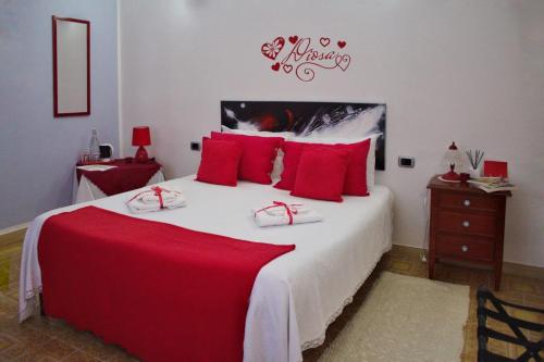 a bedroom with a large bed with red pillows at La Collina dei Ciliegi in Sarule